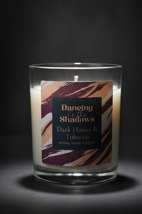 Dark honey and tobacco soy candle with a dark background 